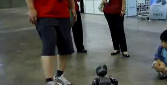 Робот-ребенок играет в футбол